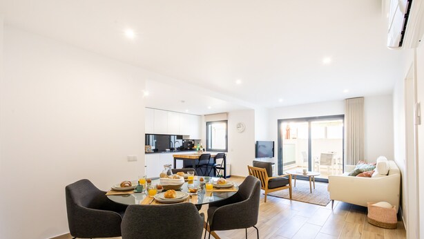 Un appartement moderne comprenant un coin repas, une cuisine et un salon.
