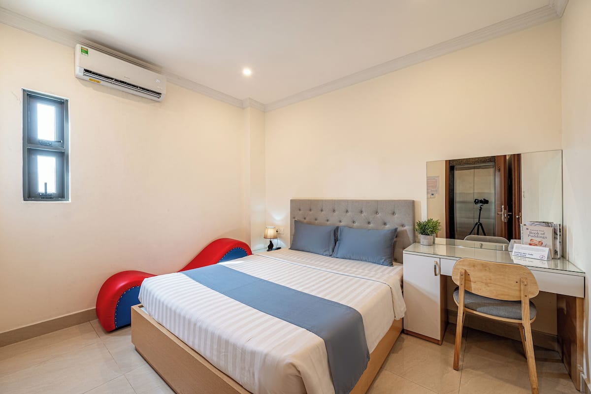 Une chambre d’hôtel équipée d’un lit, d’un bureau, d’une chaise et d’un appareil de climatisation.