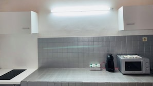 A kitchen with a microwave, a kettle, and a box of sugar. - Comfortable air-conditioned mahogany T2 Lamentin near Galleria shopping center (Le Lamentin)