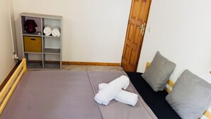 A neatly made bed with a purple bedspread, two pillows, and rolled towels on the bed. - Comfortable air-conditioned mahogany T2 Lamentin near Galleria shopping center (Le Lamentin)