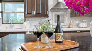 Una encimera de cocina con una botella de vino y copas.