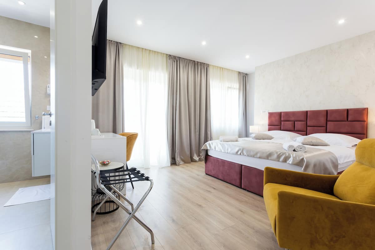 Une chambre d’hôtel moderne équipée d’un lit, d’un bureau, d’une chaise et d’un téléviseur.