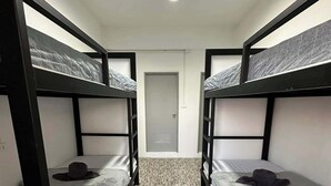 Una habitación con literas, una puerta y un suelo estampado.