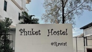 Un letrero de Phuket Hostel con el identificador @Rawai.