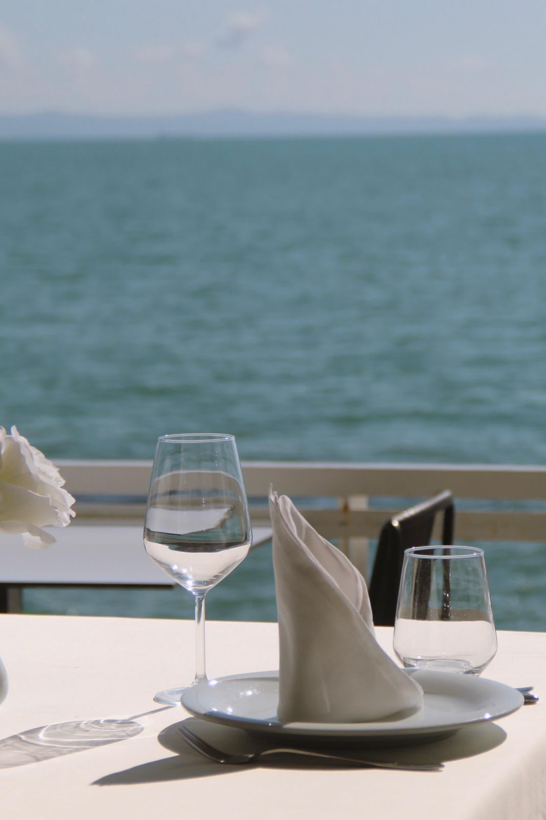 Ein Tisch für zwei Personen mit freiem Blick auf das Meer im Hintergrund.