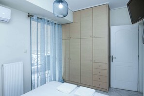 Une chambre avec un lit, une armoire, un radiateur et un téléviseur.