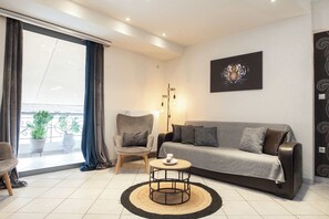 Un salon moderne avec un canapé, un fauteuil, une table basse et un tableau représentant un tigre.