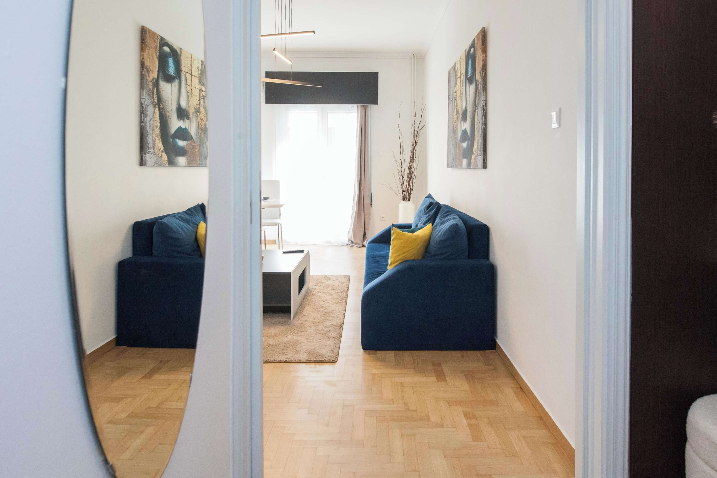 A living room with two sofas, a coffee table, and artwork on the walls.