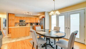 A modern kitchen with wooden cabinets, a central island, and a dining area with a round table and four chairs. - 4 Mi to Dtwn: Pet-friendly Home in Utica (Utica)
