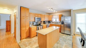A spacious kitchen with wooden cabinets, stainless steel appliances, and a large island. - 4 Mi to Dtwn: Pet-friendly Home in Utica (Utica)