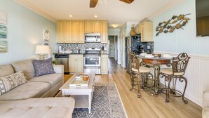A spacious living room with a sofa, coffee table, and a dining area with chairs and a table.