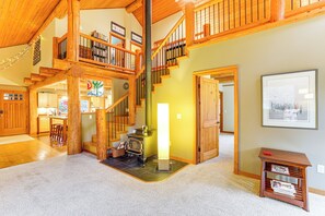 A spacious living area with a wooden staircase, a fireplace, and a bookshelf. - 11 Mi to Olympic NP: Port Angeles Retreat w/ Deck (Port Angeles)