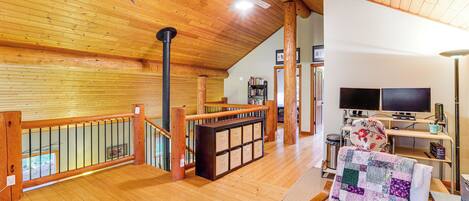 A spacious living area with a wooden ceiling, a fireplace, a television, and a comfortable seating area.