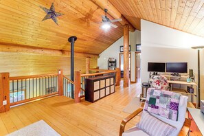 A spacious living area with a wooden ceiling, a fireplace, a television, and a comfortable seating area. - Peaceful Port Angeles Retreat w/ Scenic Deck (Port Angeles)