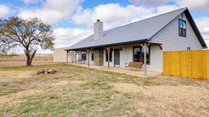 A single-story house with a covered porch, a chimney, and a fenced yard. - Private Hot Tub & Pickleball Court: Baird Home! (Baird)