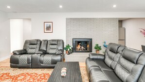 Una sala de estar con chimenea, sofás de cuero y una mesa de centro.