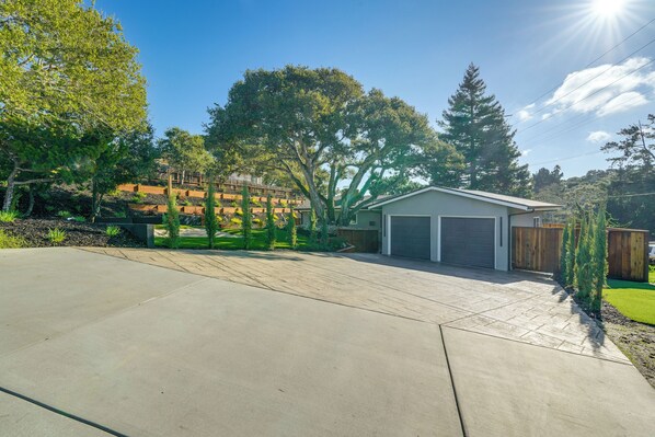 A residential garage with a covered driveway, surrounded by trees and a well-maintained lawn. - 2 Mi to Beach: Home w/ Patio in Del Rey Oaks! (Monterey)