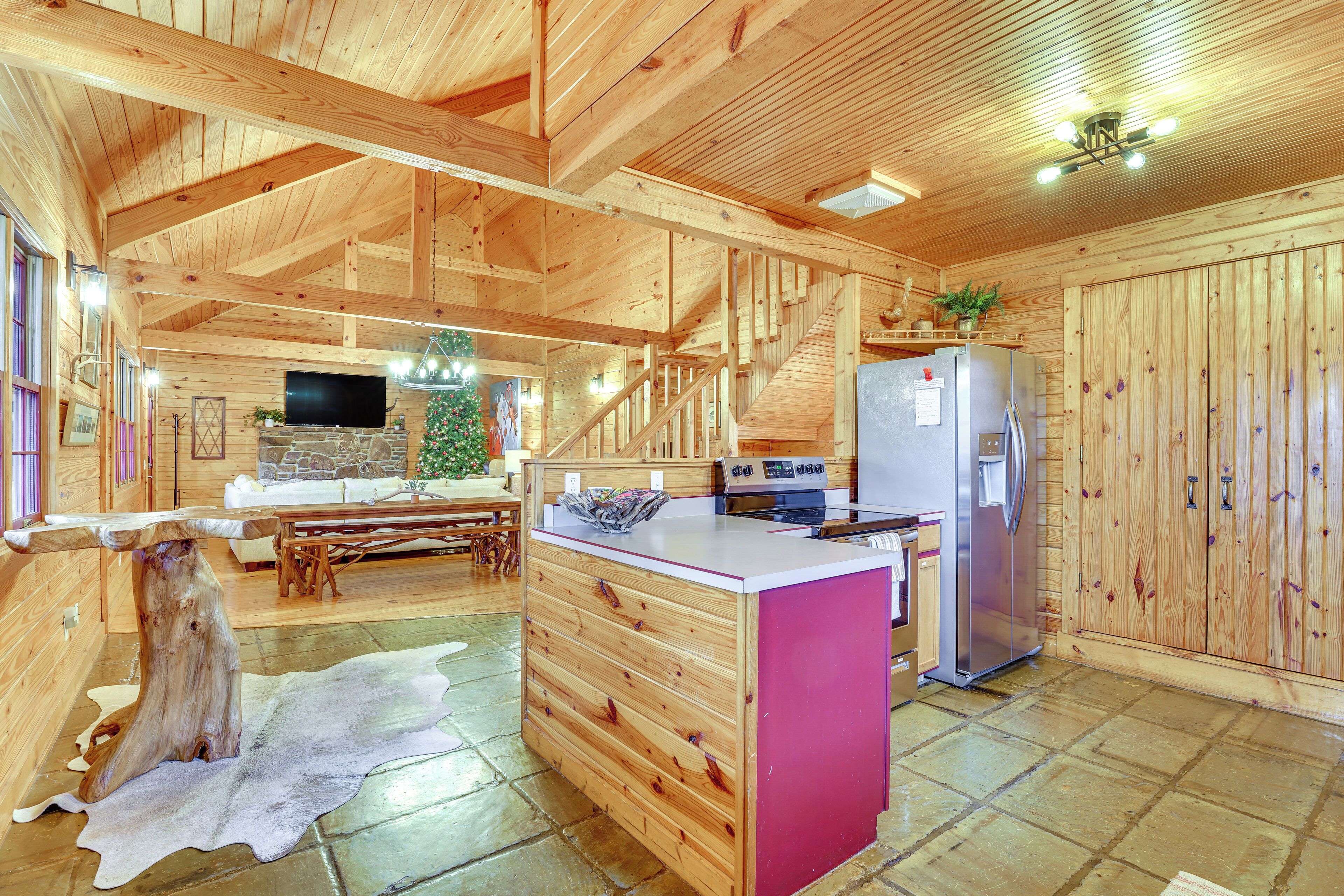 Een houten chalet inrichting met een keuken, eethoek en een grote houten tafel.