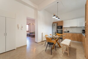 A modern kitchen with white cabinets, a central island, and pendant lighting.