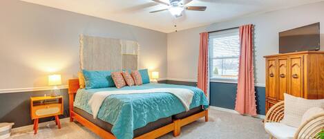 A bedroom with a bed, nightstand, dresser, and a ceiling fan.