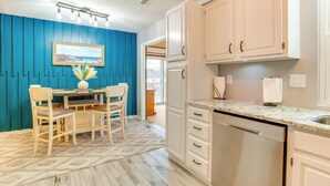 A kitchen with white cabinets, a marble countertop, and a dining area with a table and chairs. - 13 Mi to Arrowhead Stadium: Blue Springs Home! (Blue Springs)
