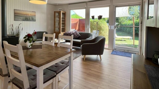 Una sala de estar moderna con comedor, ventanas amplias y vistas al exterior.