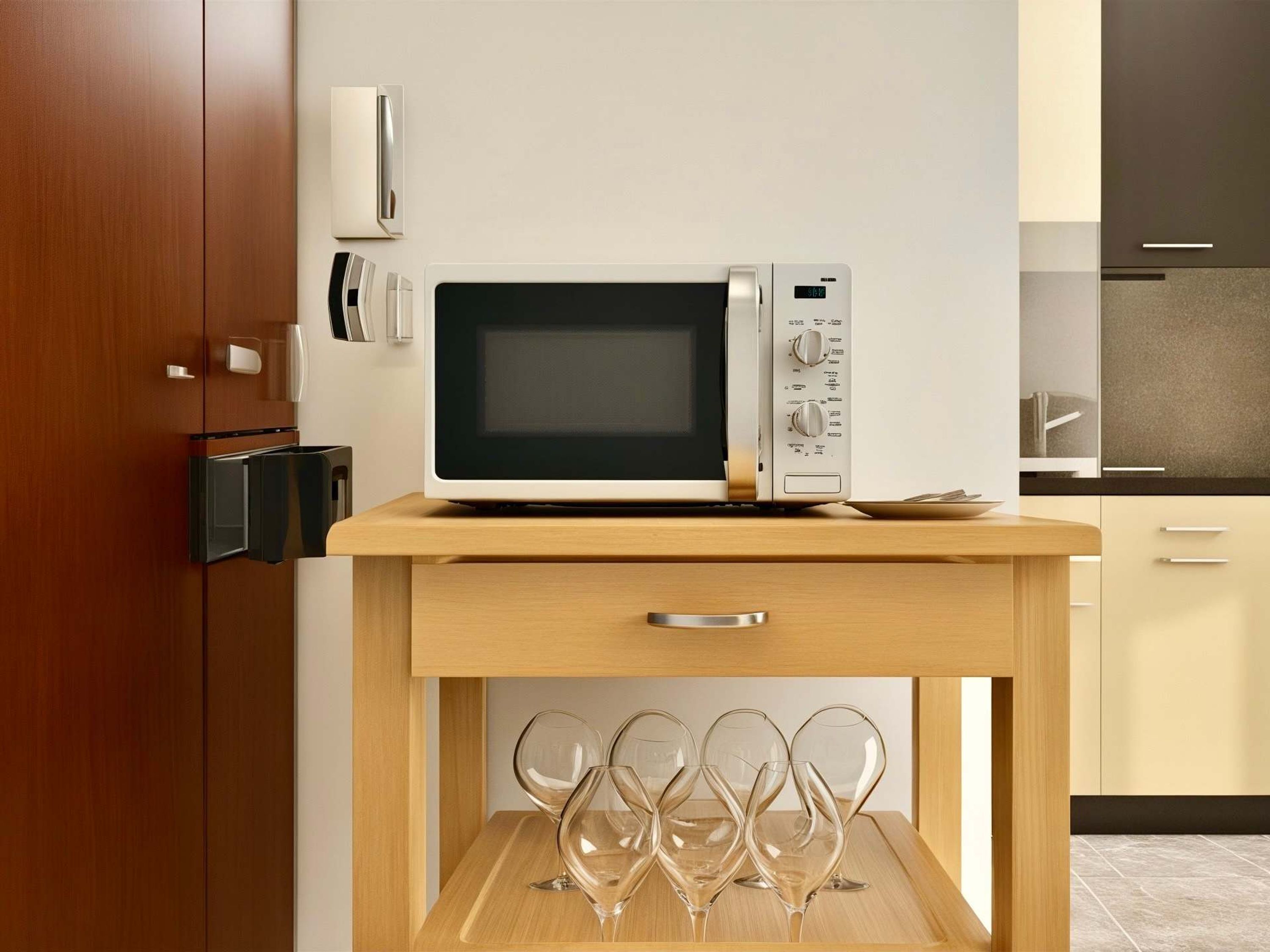A modern kitchen with a built-in microwave, a wooden cabinet, and a wine glass holder.