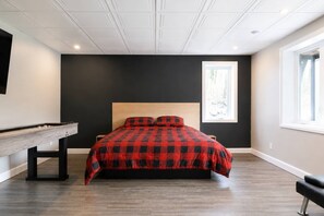 A bedroom with a bed, a desk, a window, and a view of trees. - Spa, Mountains & Ultimate Comfort | Le Jameson (Saint-Philémon)