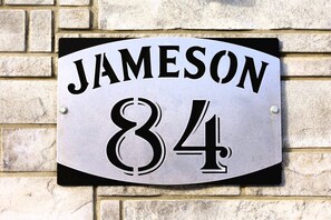 A house number sign with 'JAMESON 84' on a brick wall. - Spa, Mountains & Ultimate Comfort | Le Jameson (Saint-Philémon)