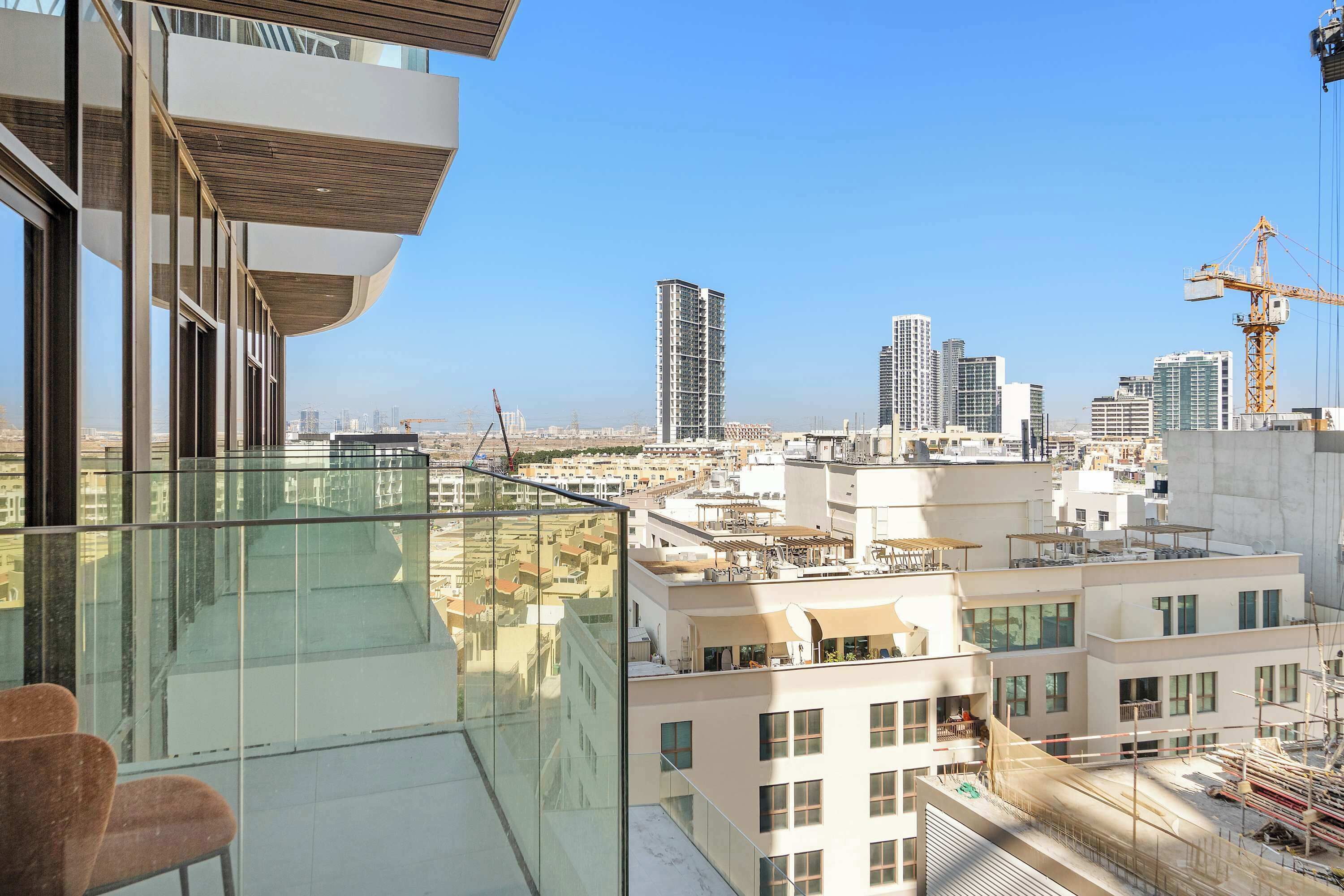 A high-rise building with a glass balcony, modern architecture, and a cityscape view.