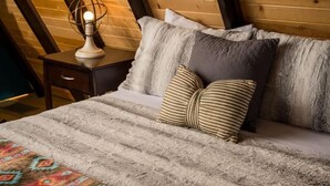 A bed with a striped blanket, a patterned throw, and striped pillows.