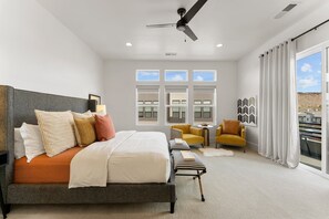 A bedroom with a bed, a ceiling fan, a window with curtains, a small table, and a chair. - Villa #26 At Bloomington Country Club - Sunset Retreat 4 Bedroom Townhouse (St. George)