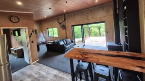 Eine moderne Küche mit Holzboden, einem großen Esstisch und einem Kühlschrank.