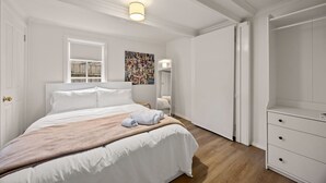 Un dormitorio con una cama grande, una mesita de noche, un espejo y un armario.