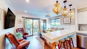 A modern kitchen with a central island, bar stools, and pendant lighting. - Oceanside Villa! Heated Pool, Hot Tub and Fitness Center (Hilton Head Island)