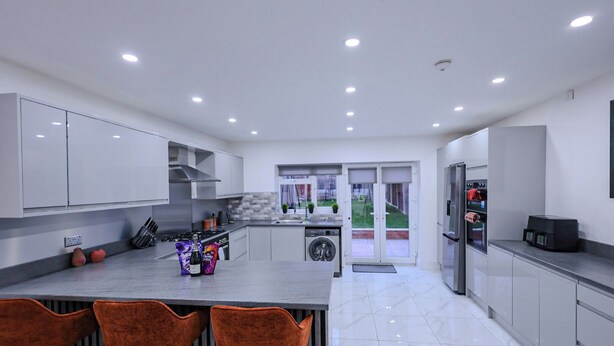 A modern kitchen with a central island, stainless steel appliances, and a view to the outdoors. - Sleeps17 Bliss 7-bedroom Luxury Escape Birmingham (Birmingham)
