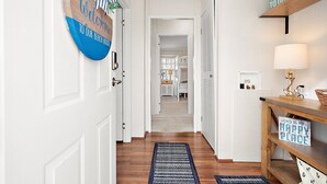 A hallway with a welcome sign, a lamp, and a 'This is my happy place' sign.