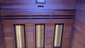 Una sauna con tres paneles de calefacción visibles y un panel de control en la parte superior.