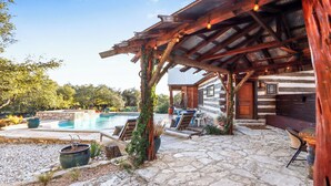 Un rifugio rustico con patio in pietra, posti a sedere all'aperto e una piscina.