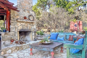 A stone fireplace, rustic furniture, and a stone wall.