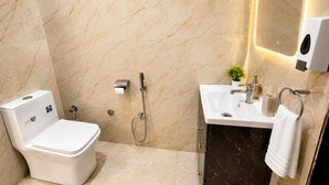 A modern bathroom with a toilet, a shower, a sink, and a towel rack. - Opal Villa by JMD Group (New Delhi)