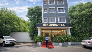 A modern building with a sign reading 'JMD AEROVILLA' and a red carpet leading to the entrance. - Opal Villa by JMD Group (New Delhi)