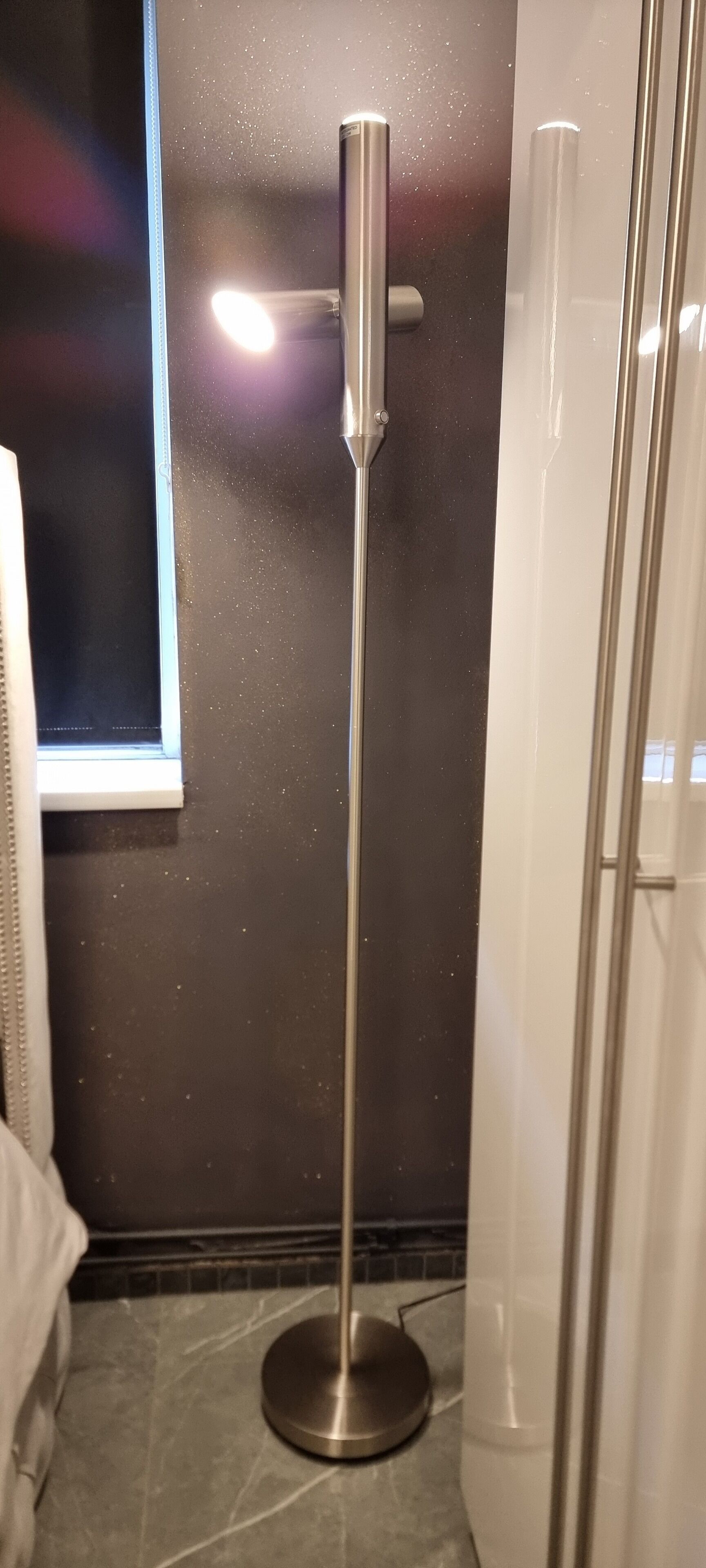 Un bagno con uno specchio a parete, una finestra e una zona doccia.