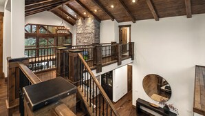 Un loft amplio con techo alto, vigas de madera a la vista y chimenea de piedra.