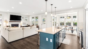 A modern kitchen with a large island, a built-in oven, and a dining area with a view. - Seabrook Glamping in the Woods | Hot Tub, Fire Pit, 3BR, Sleeps 9 (Pacific Beach)