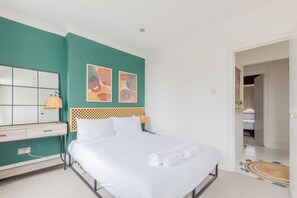 A neatly arranged bedroom with a bed, bedside table, and a mirror. - Perfect 2BD Duplex with Private Balcony, Islington (Greater London)