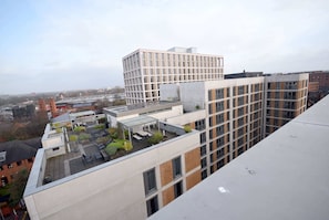 A multi-story building with a rooftop terrace featuring outdoor seating and greenery. - Suite Life 3: 2-Bed, 2-Bath in New Cross (Greater Manchester)