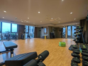 A gym with exercise equipment, large windows, and a wooden floor. - Suite Life 3: 2-Bed, 2-Bath in New Cross (Greater Manchester)