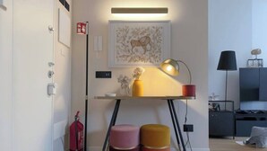 Habitació moderna amb escriptori, làmpada i dos petjacs.