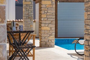 An outdoor seating area with a pool in the background. - Villa Malena in Svetvincenat (Svetvincenat)